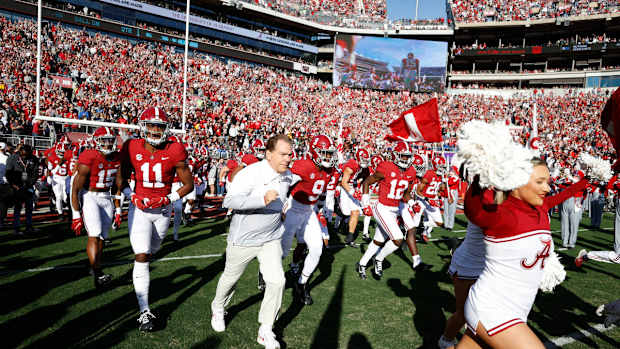 Nick Saban leads Alabama on to the field
